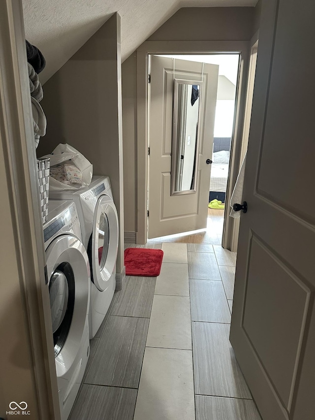 laundry area featuring a textured ceiling, laundry area, and washing machine and clothes dryer