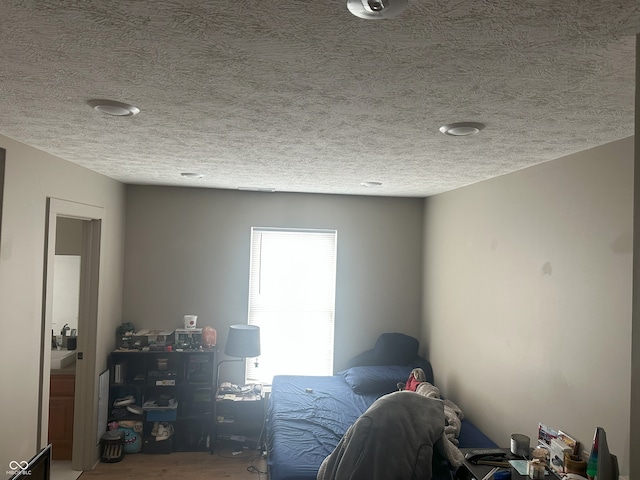 unfurnished bedroom featuring a textured ceiling and wood finished floors