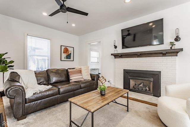 living room with recessed lighting, a ceiling fan, and a fireplace