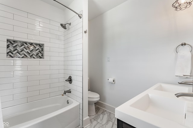 full bath featuring toilet, marble finish floor, a sink, tub / shower combination, and baseboards