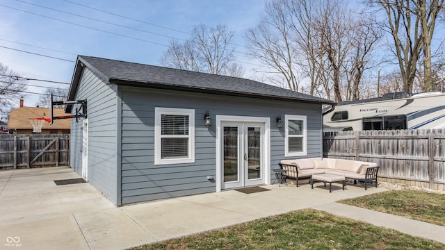 rear view of property with roof with shingles, an outdoor hangout area, an outdoor structure, a fenced backyard, and a patio