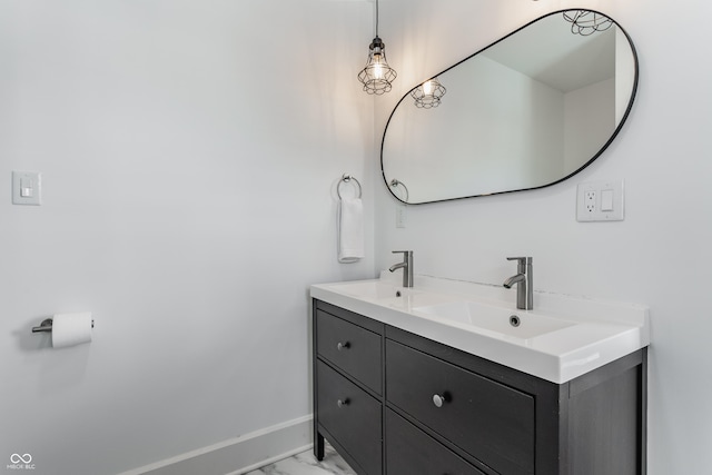 bathroom featuring a sink, marble finish floor, baseboards, and double vanity