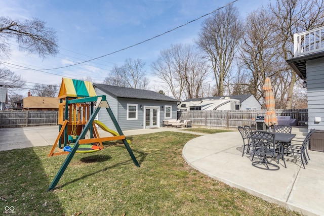 view of yard with a patio, a playground, french doors, and a fenced backyard