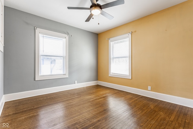 spare room with a healthy amount of sunlight, a ceiling fan, baseboards, and hardwood / wood-style floors