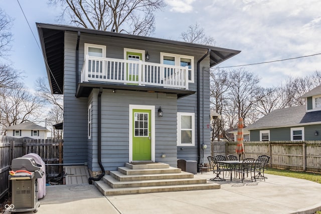 back of house featuring a patio area, a fenced backyard, entry steps, and a balcony