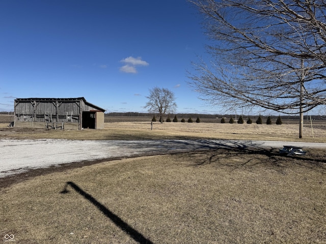 view of yard featuring a rural view, an outbuilding, and an outdoor structure