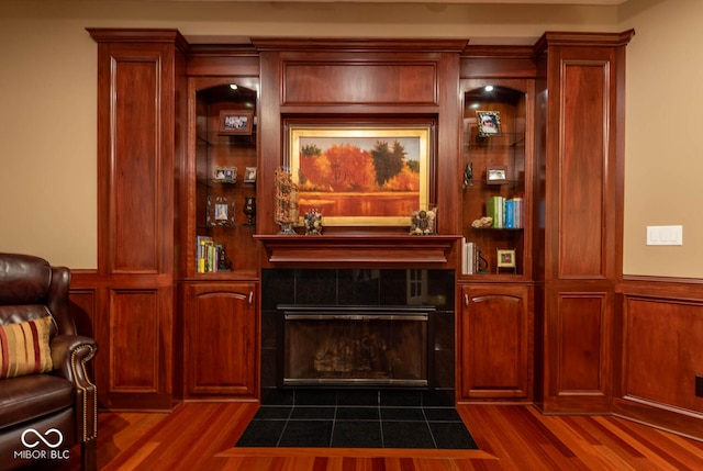 interior space featuring a tile fireplace and dark wood-style flooring