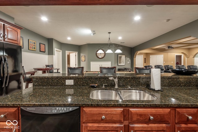 kitchen with open floor plan, dark stone countertops, arched walkways, black appliances, and a sink