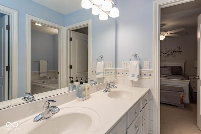 bathroom featuring ceiling fan, double vanity, ensuite bathroom, and a sink