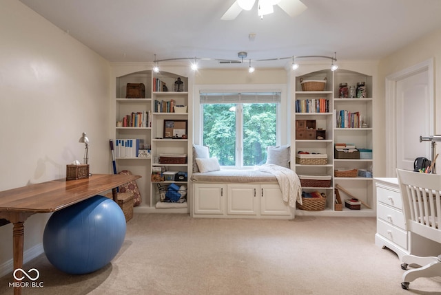 office space featuring built in features, light colored carpet, and a ceiling fan