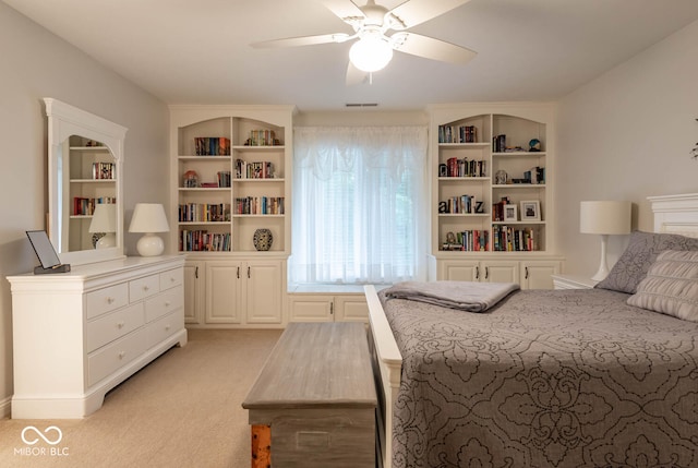 bedroom with visible vents, light colored carpet, and a ceiling fan