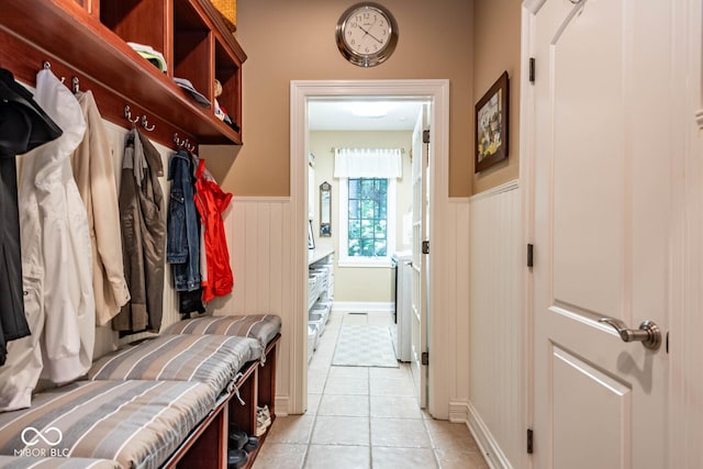 mudroom with light tile patterned floors and a wainscoted wall