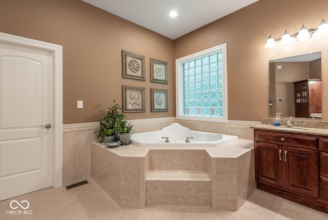 bathroom with visible vents, a garden tub, wainscoting, tile patterned flooring, and vanity