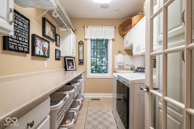 clothes washing area featuring visible vents, washing machine and dryer, cabinet space, light tile patterned floors, and baseboards