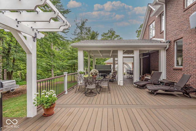 wooden terrace with outdoor dining area and a pergola