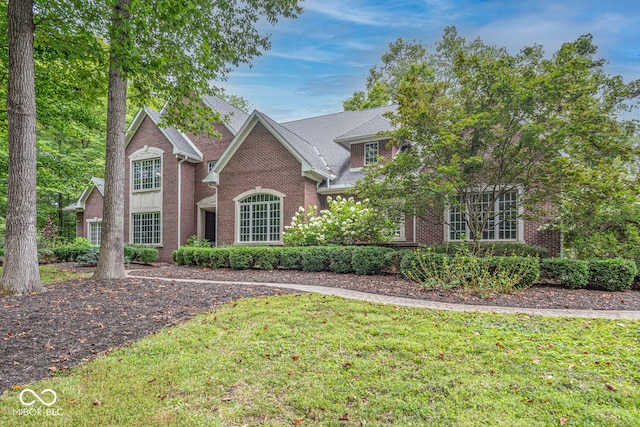 traditional-style home with a front lawn and brick siding