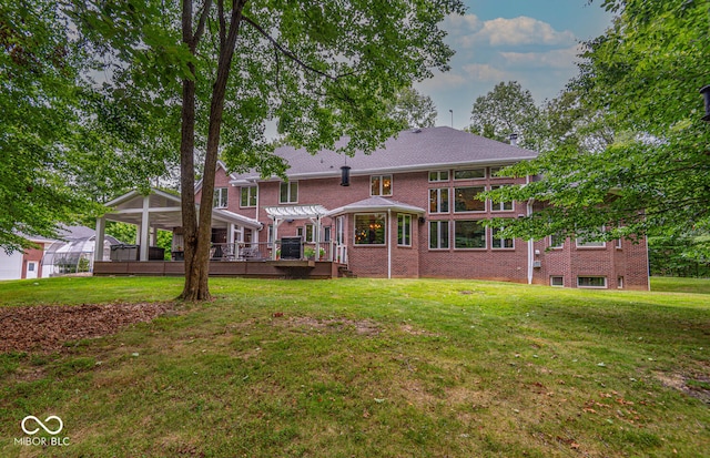 back of property with a lawn, brick siding, and a pergola