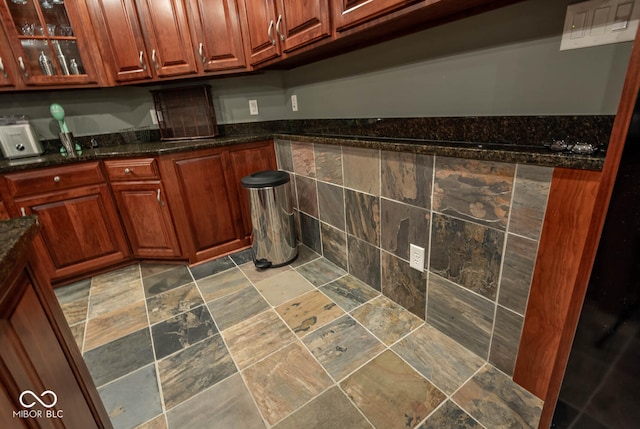 kitchen with stone finish flooring and glass insert cabinets