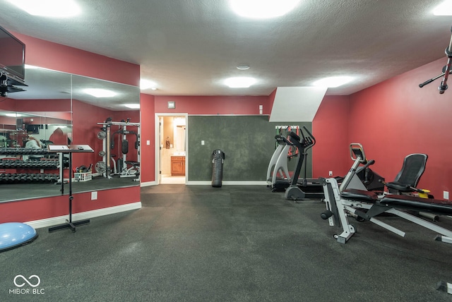 workout area with baseboards and a textured ceiling