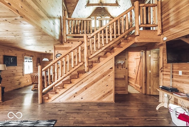 stairs with wood walls, wood ceiling, and wood finished floors