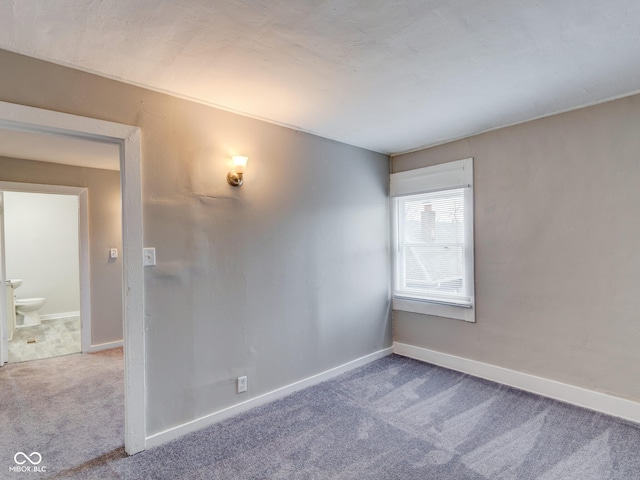 unfurnished room with carpet and baseboards