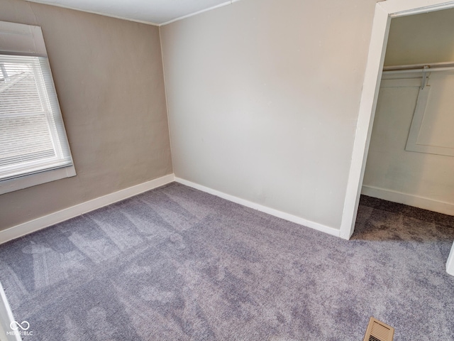 unfurnished bedroom featuring a closet, visible vents, baseboards, and carpet floors