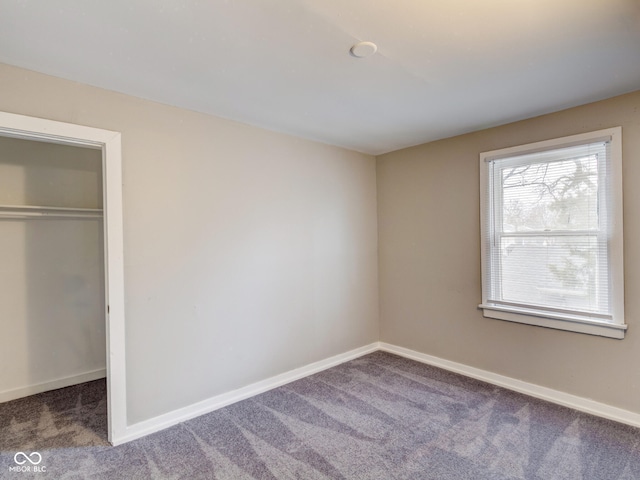 unfurnished bedroom with a closet, baseboards, and carpet