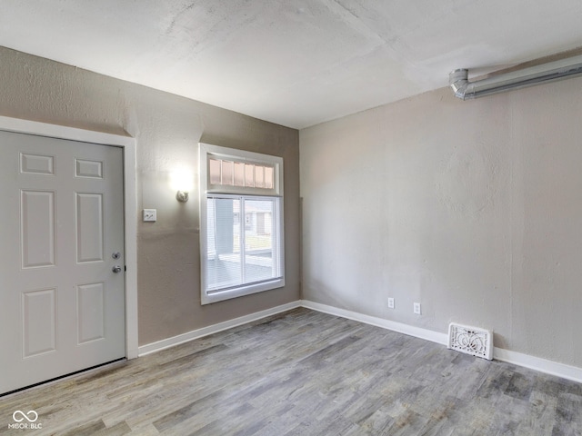 entrance foyer featuring wood finished floors, visible vents, and baseboards