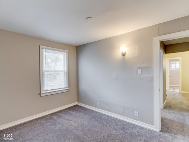 empty room featuring baseboards and carpet floors