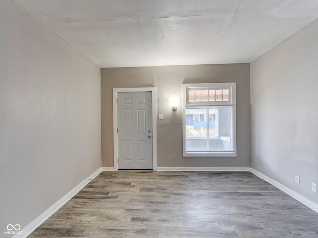 foyer featuring baseboards and wood finished floors