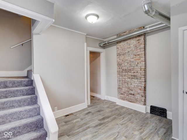 basement featuring stairway, baseboards, and wood finished floors