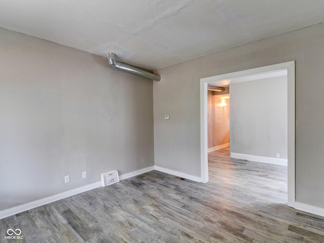 unfurnished room featuring baseboards and wood finished floors