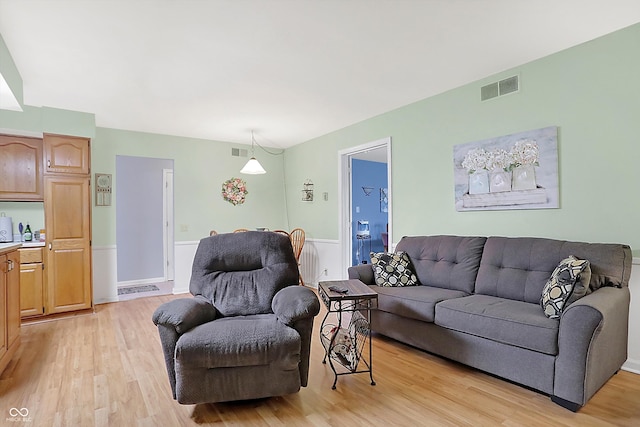 living room with light wood-type flooring and visible vents