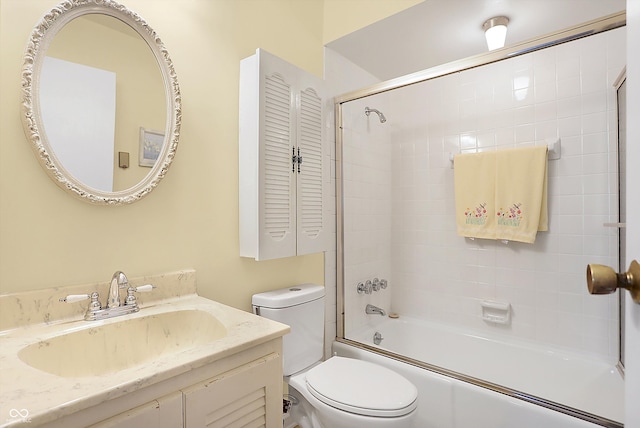 bathroom with toilet, combined bath / shower with glass door, and vanity