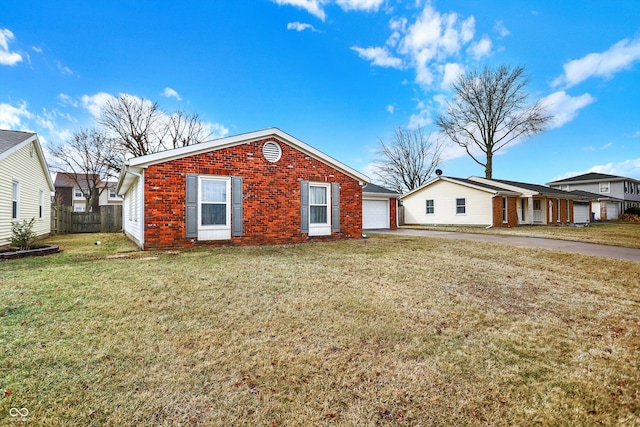 view of home's exterior with a yard, brick siding, fence, and aphalt driveway