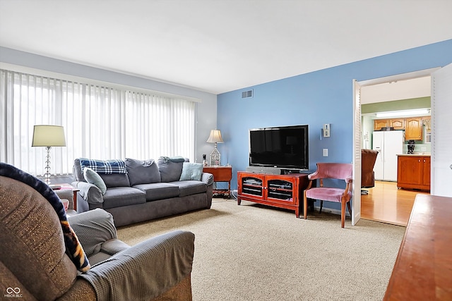 living area with light carpet and visible vents