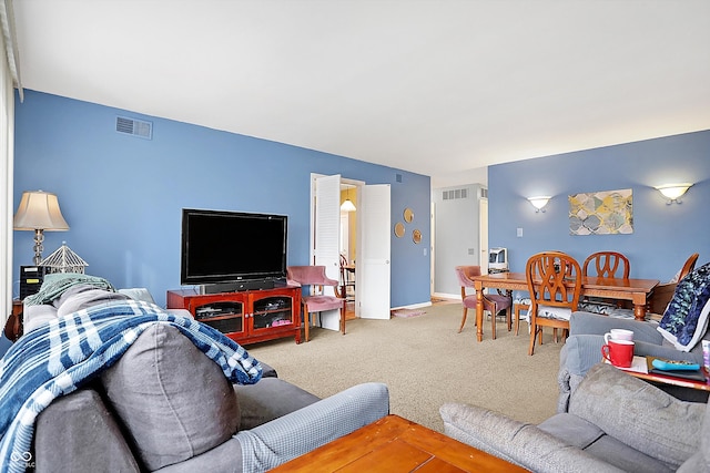 carpeted living area featuring visible vents and baseboards