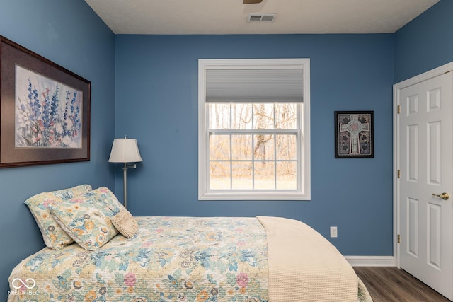 bedroom with baseboards, visible vents, and dark wood-style flooring