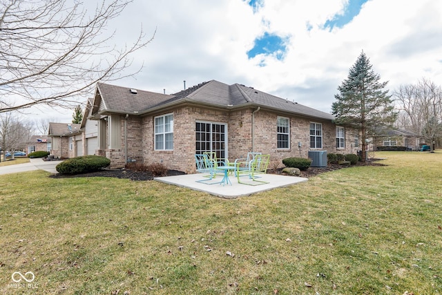 back of property featuring a yard, cooling unit, brick siding, and a patio