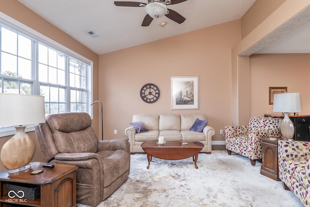 living room with ceiling fan, visible vents, vaulted ceiling, and baseboards