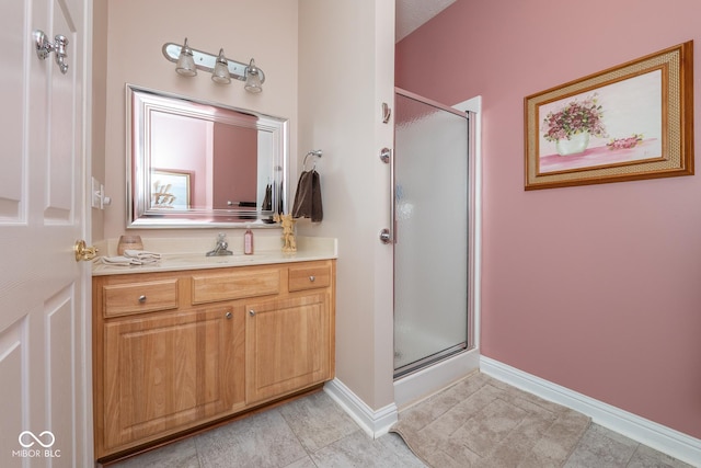 full bathroom featuring a shower stall, baseboards, tile patterned flooring, and vanity