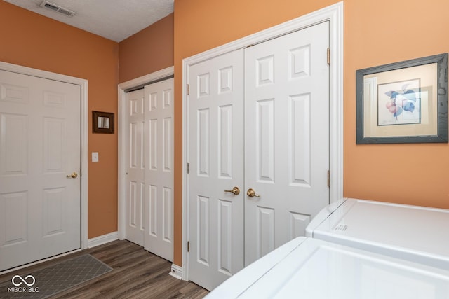 clothes washing area featuring laundry area, visible vents, dark wood-style flooring, independent washer and dryer, and a textured ceiling