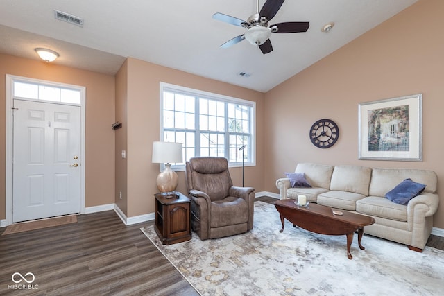 living area with lofted ceiling, wood finished floors, visible vents, and baseboards