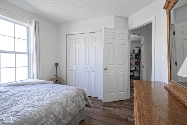 bedroom with dark wood-style floors, a closet, and a textured ceiling