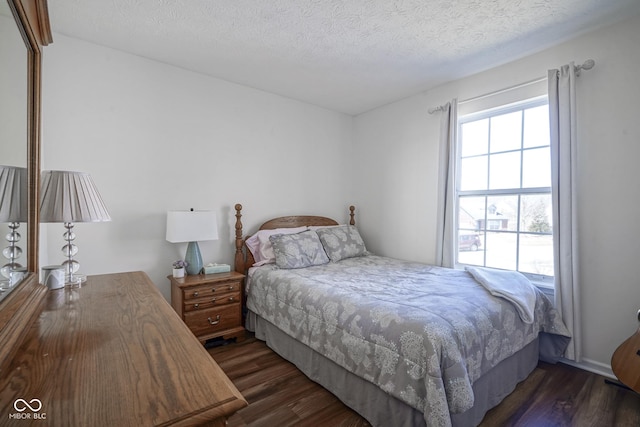 bedroom with dark wood-style floors and a textured ceiling