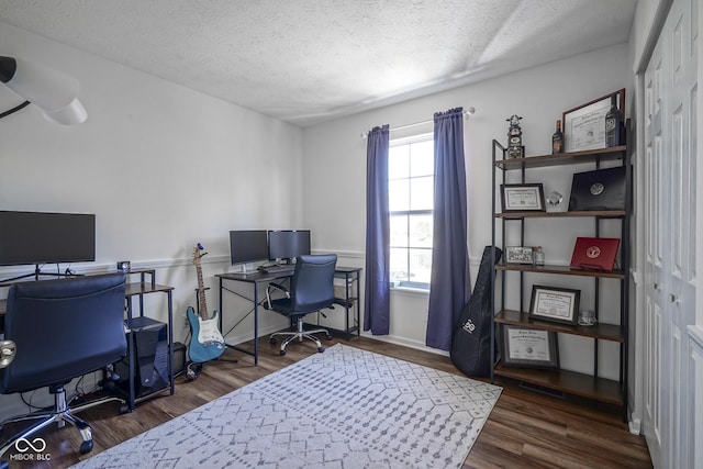 office with visible vents, a textured ceiling, and wood finished floors