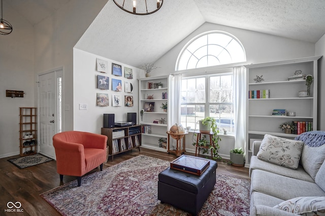 living area featuring baseboards, a textured ceiling, lofted ceiling, and wood finished floors