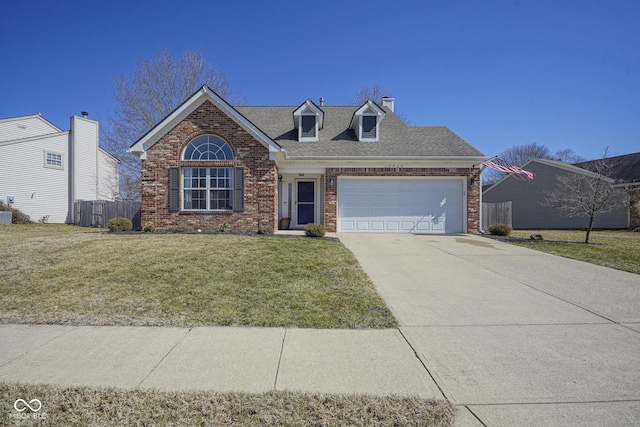 view of front facade with a front yard, roof with shingles, an attached garage, concrete driveway, and brick siding