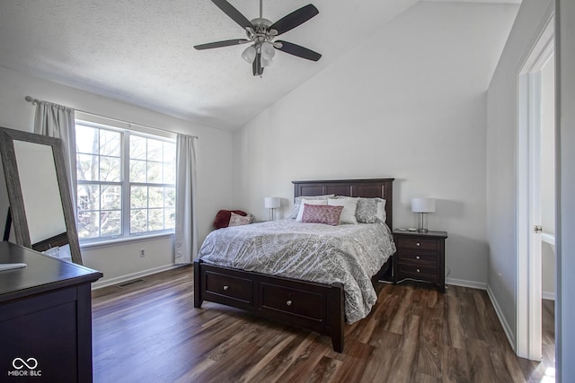 bedroom with baseboards, lofted ceiling, dark wood-type flooring, and a textured ceiling