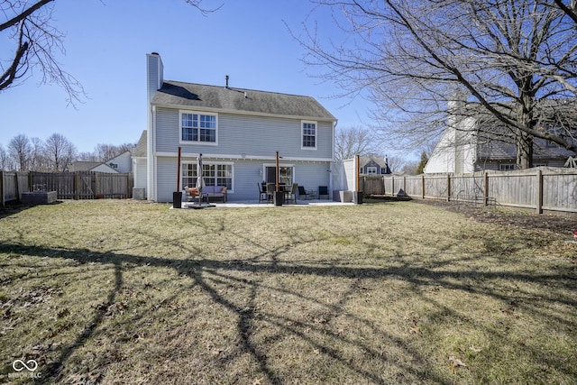 back of property featuring a patio area, a yard, a chimney, and a fenced backyard